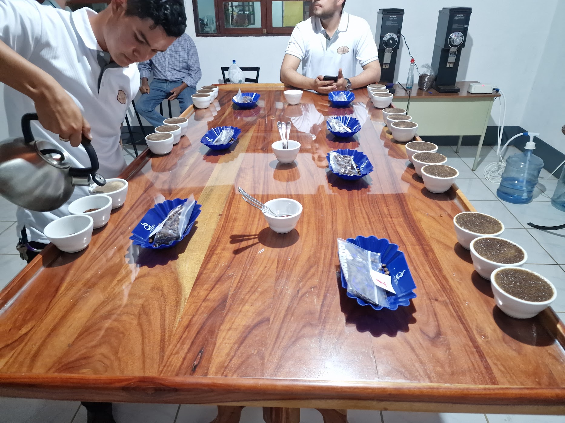 Cupping table set with cups and sample bags at an exporting facility
