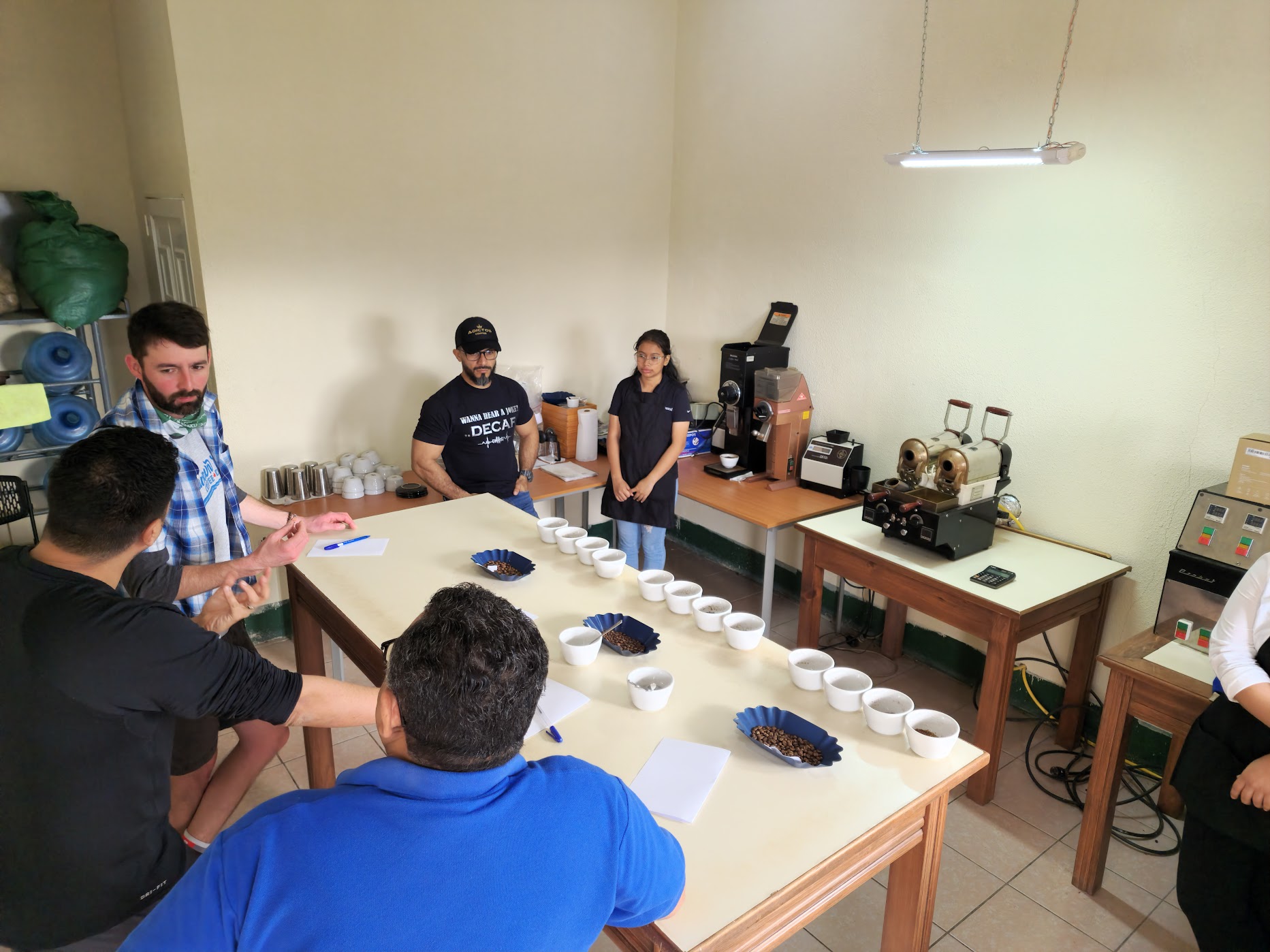 Producers and visitors discussing coffee around a cupping table